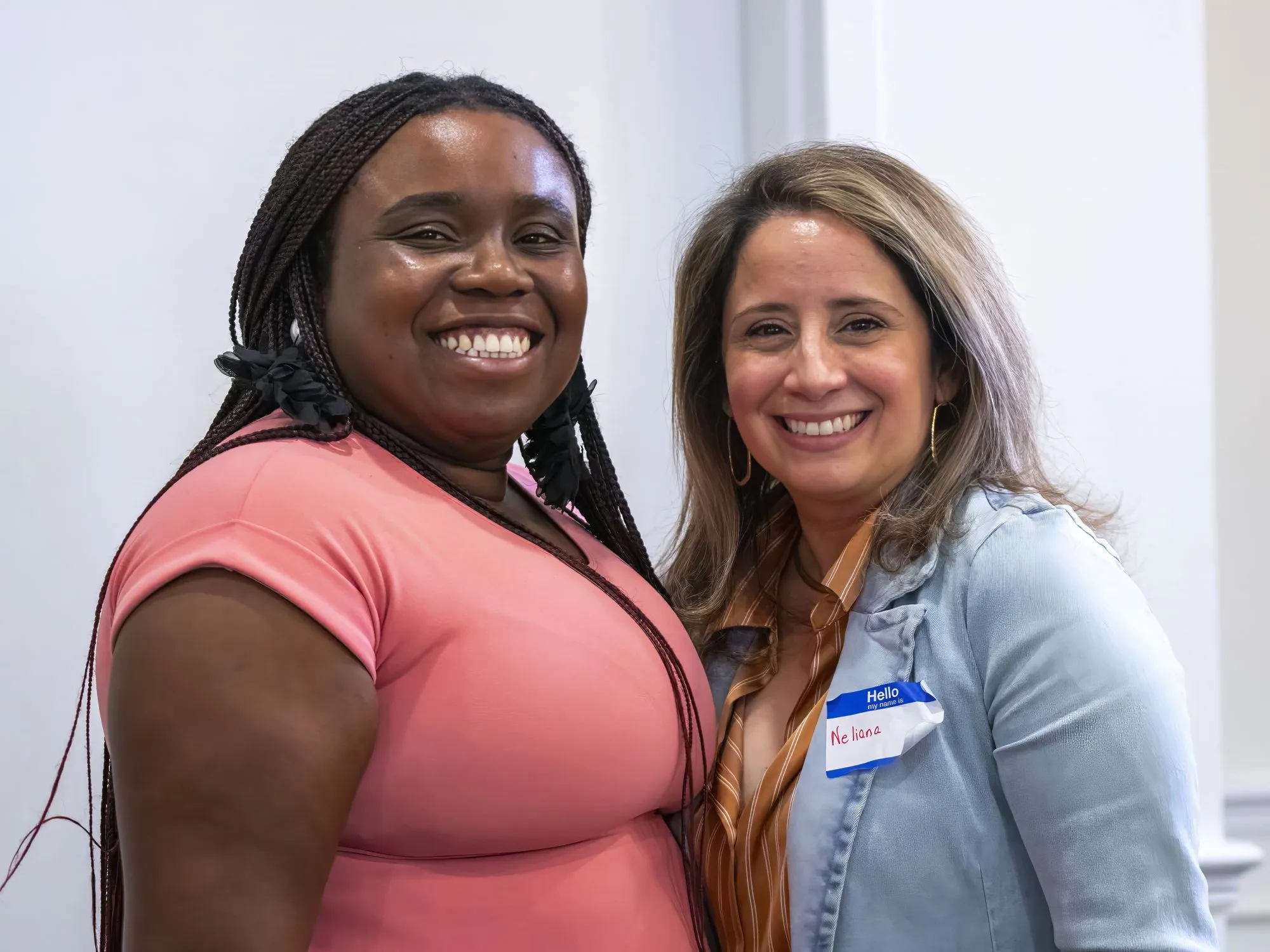 Two women standing side by side, smiling