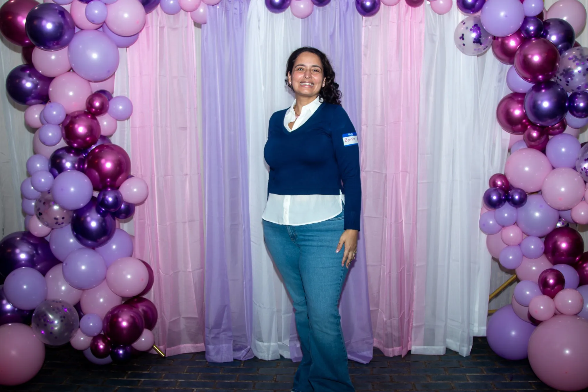 A woman arriving at the 2026 conference, photographed at the entrance backdrop