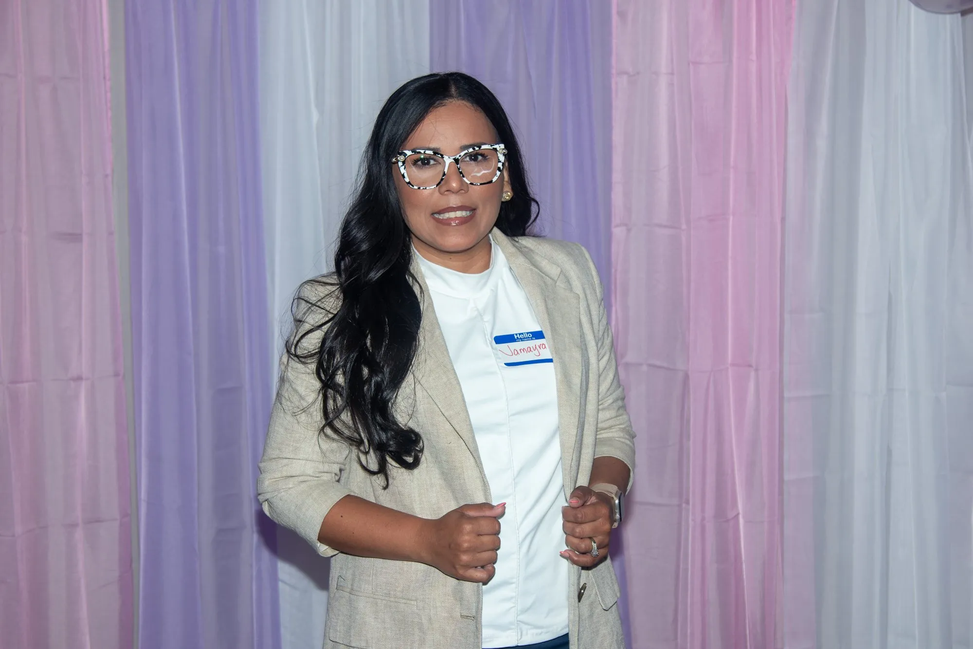 A woman smiling in front of the entrance curtain