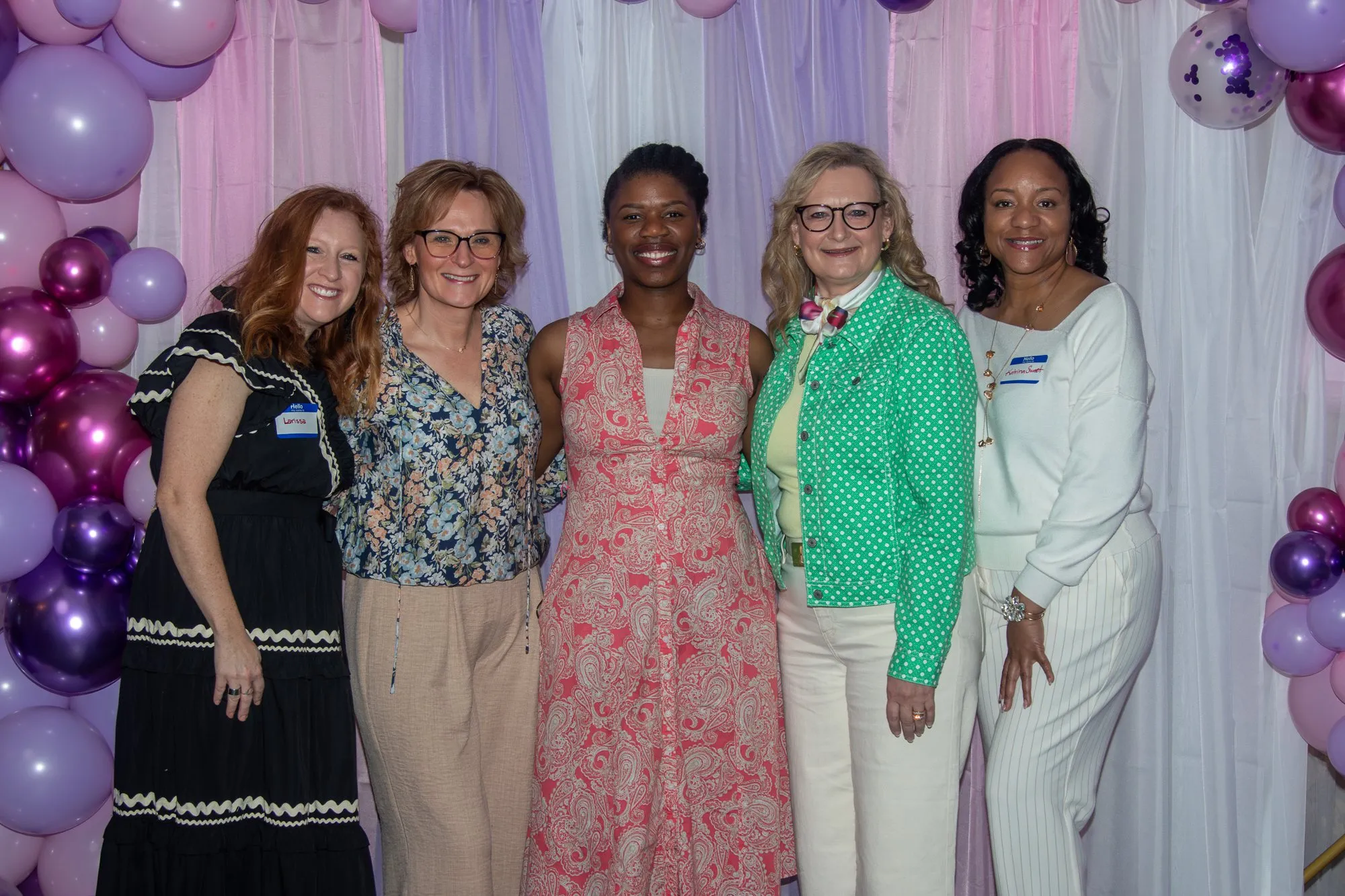 A group of women gathered at the entrance backdrop