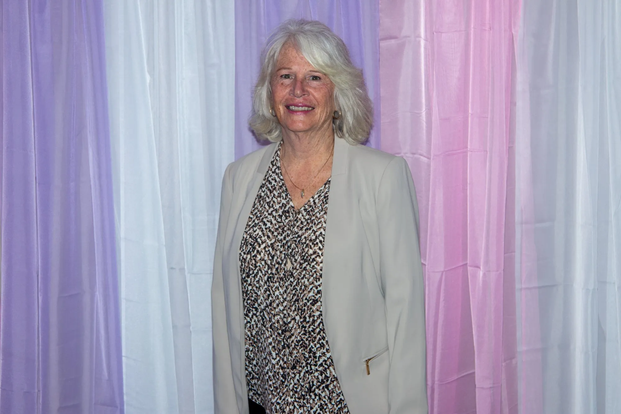 A woman smiling at the entrance backdrop