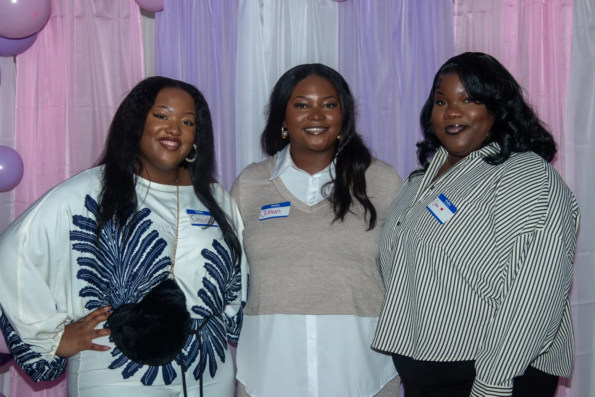 Three women together at the entrance backdrop