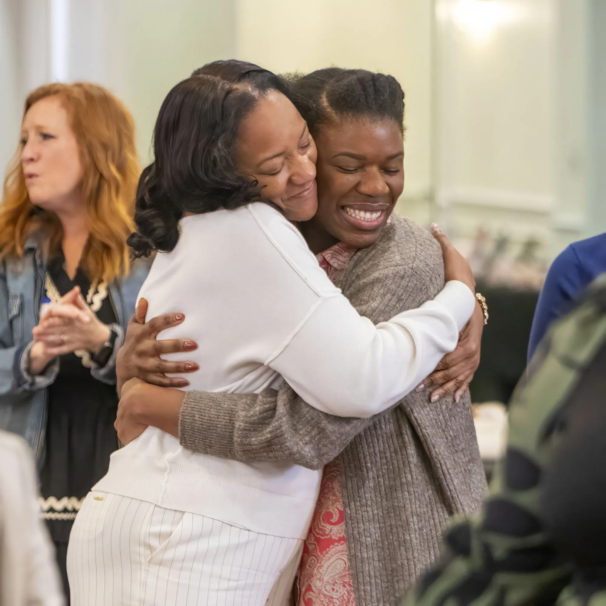 Two women embracing after prayer