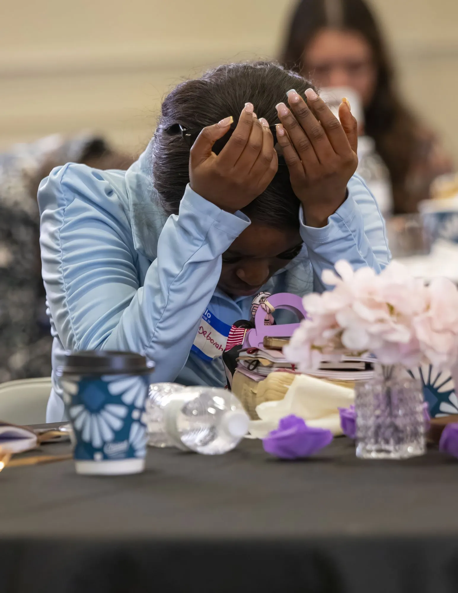 A woman praying with her head in her hands