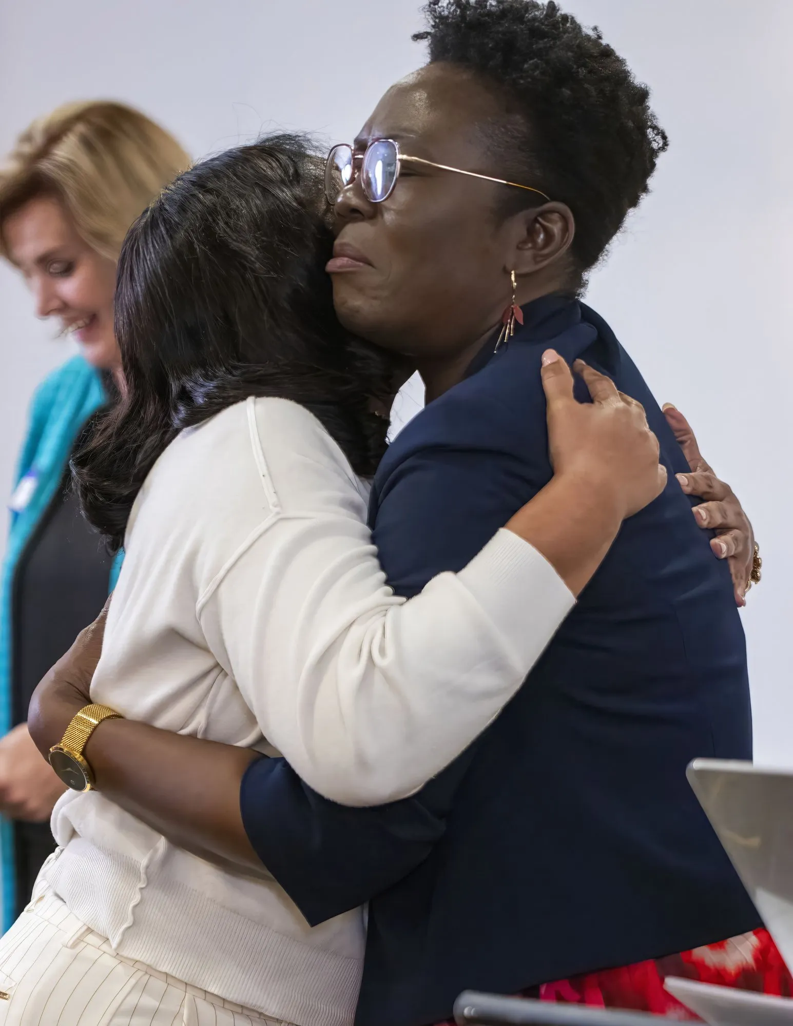 Two women holding each other during prayer