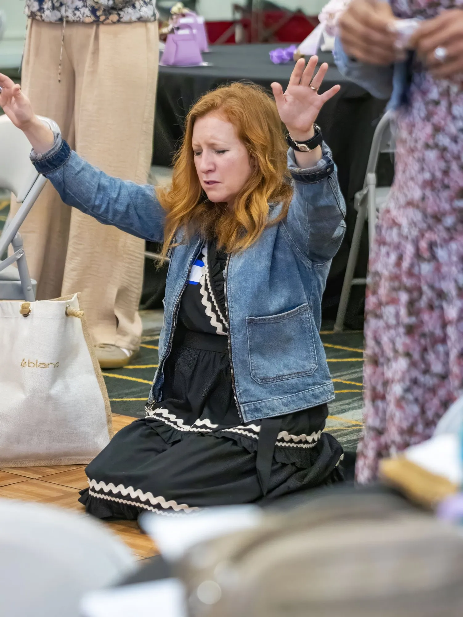 A woman kneeling in prayer