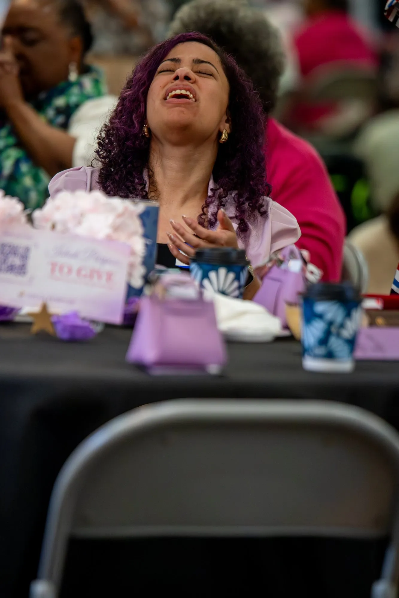 A woman worshipping with her hand on her heart